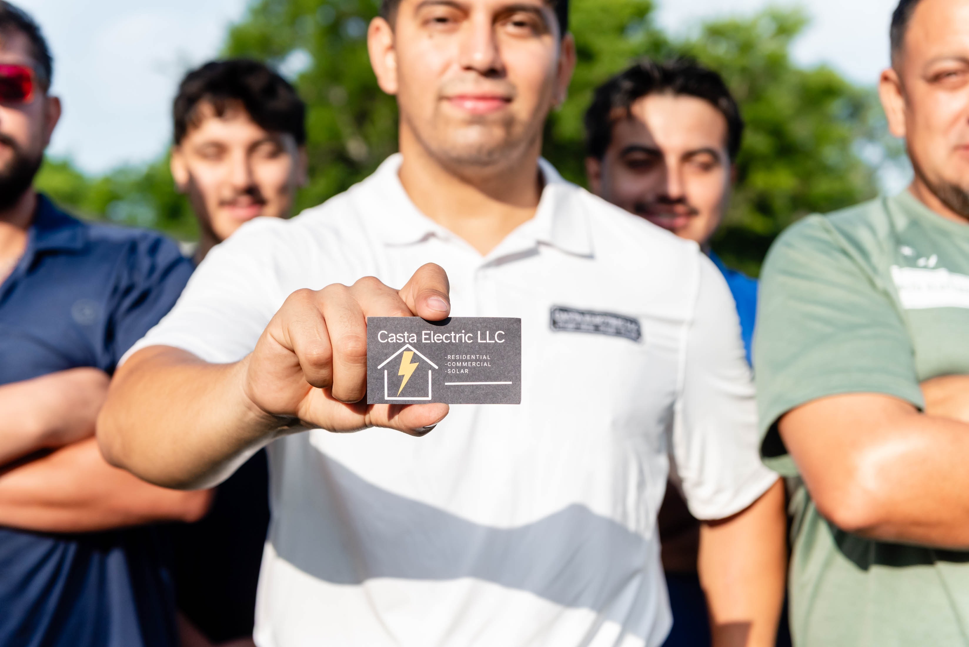 Casta Electric LLC business card held up by team member — Midlothian TX electrician