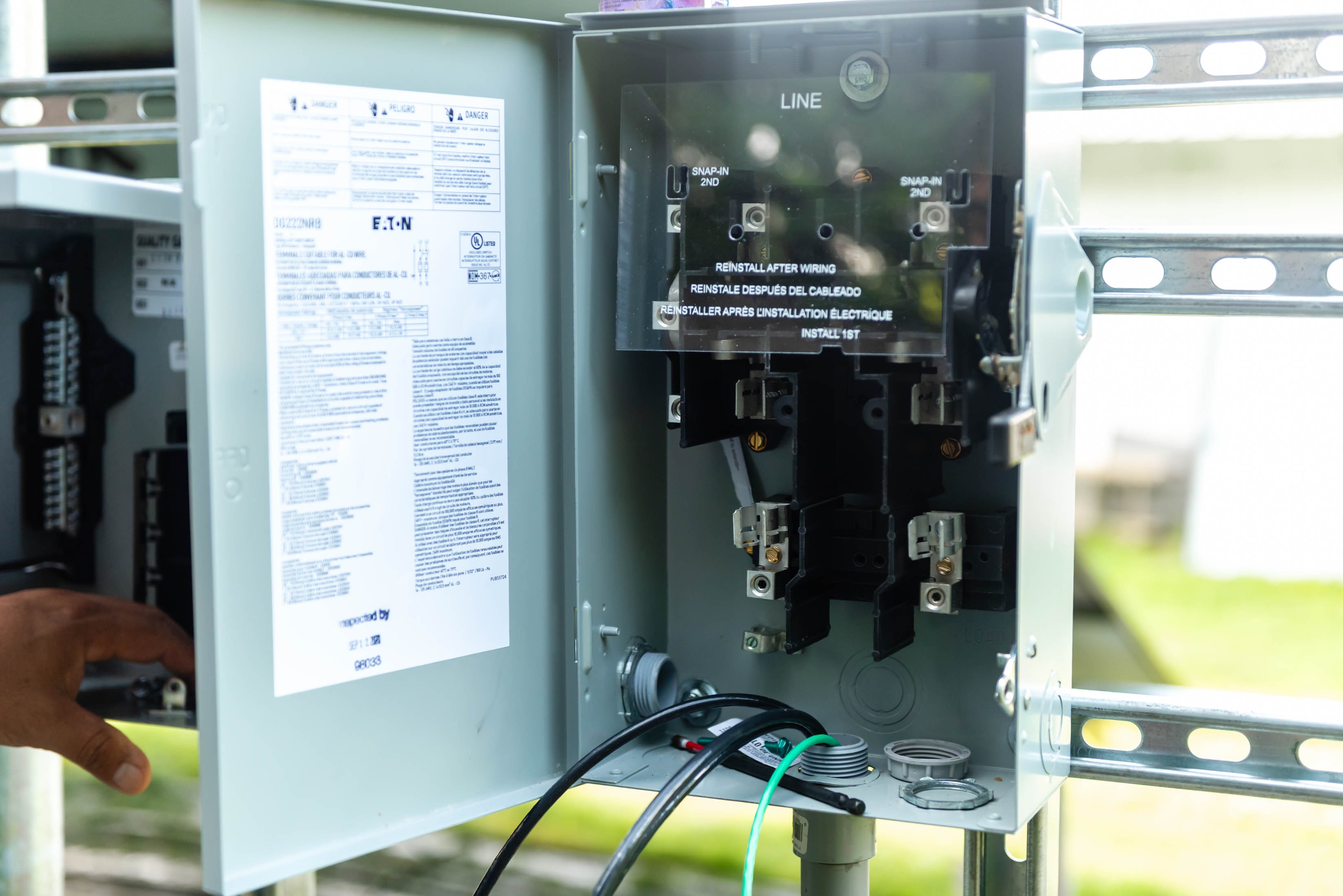 Open Eaton DG222NRB solar disconnect panel on racking structure — Casta Energy solar install