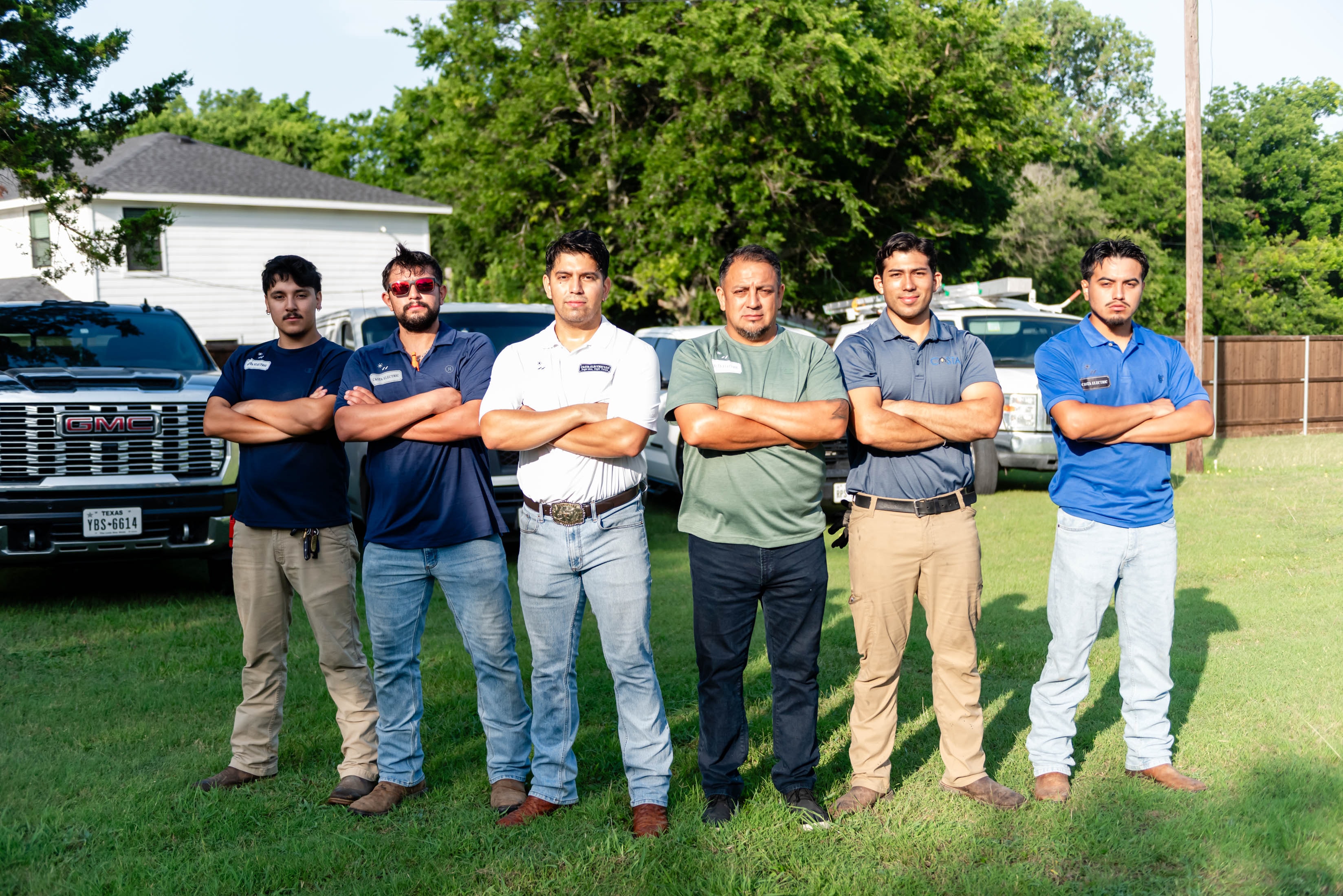 Full Casta Energy crew standing arms crossed in front of fleet trucks — Midlothian TX