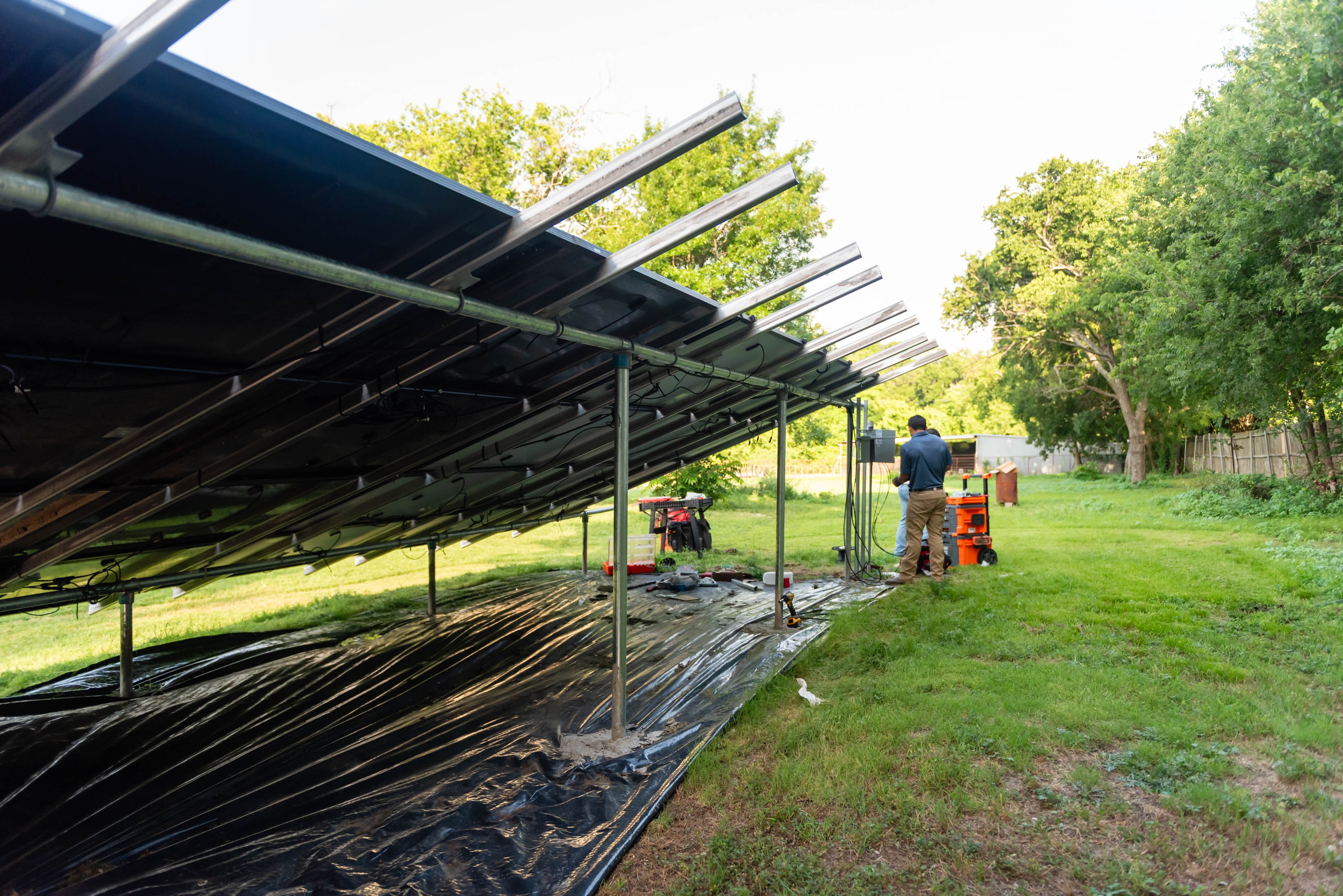 Casta Energy crew wiring ground-mount solar array in rural DFW backyard