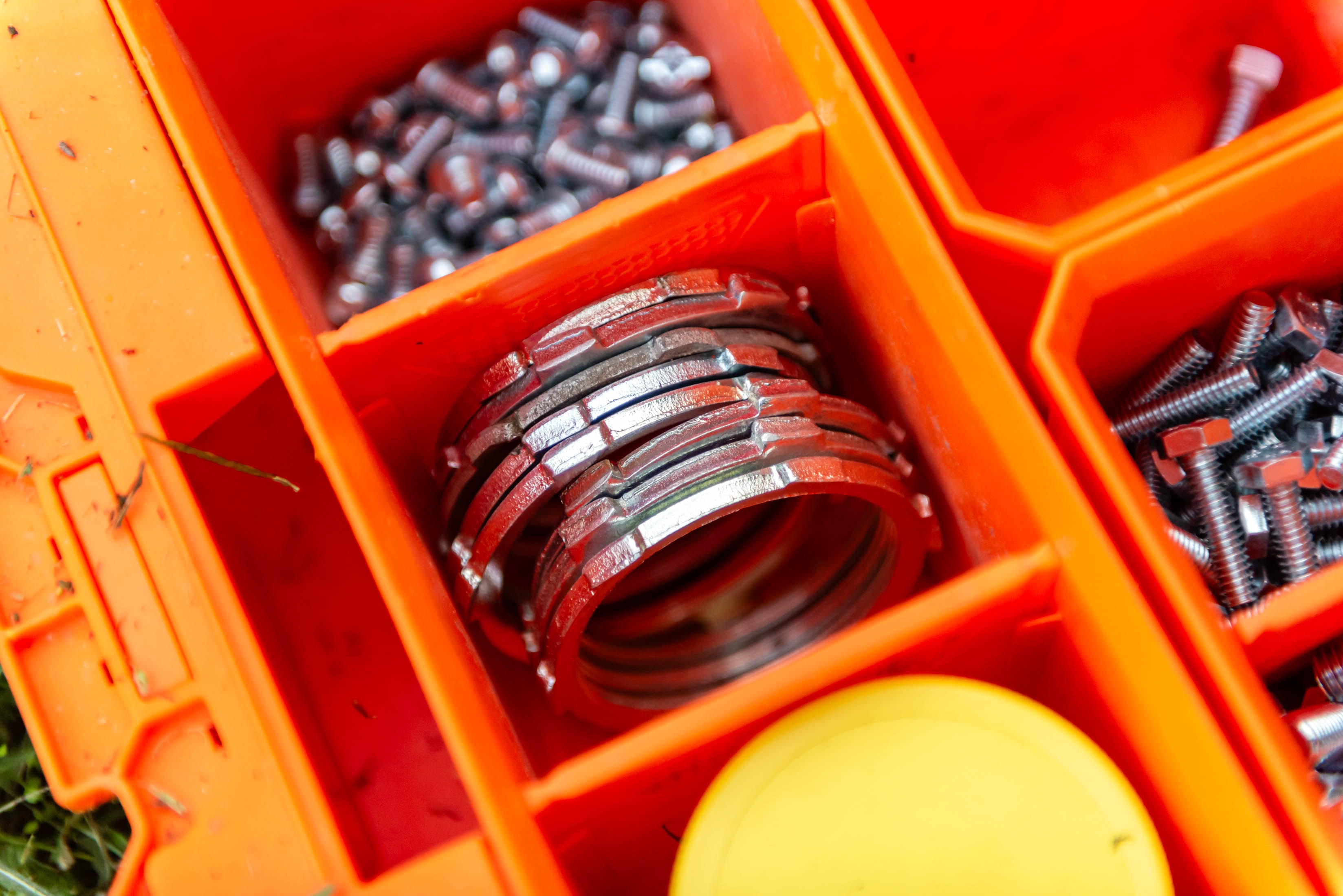 Organized electrical hardware in orange parts box — Casta Energy job site