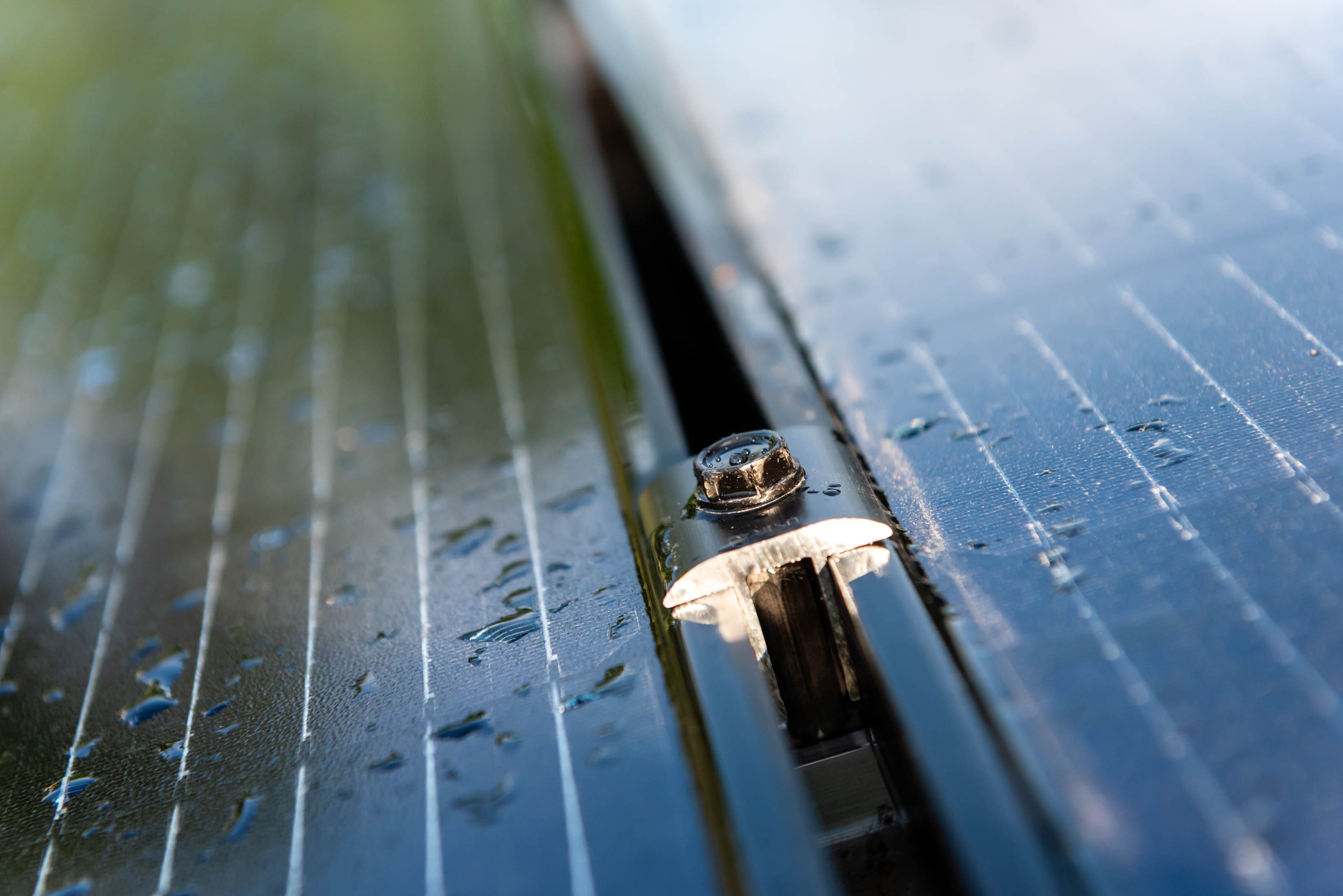 Close-up of solar panel mounting hardware with water droplets — Casta Energy installation detail