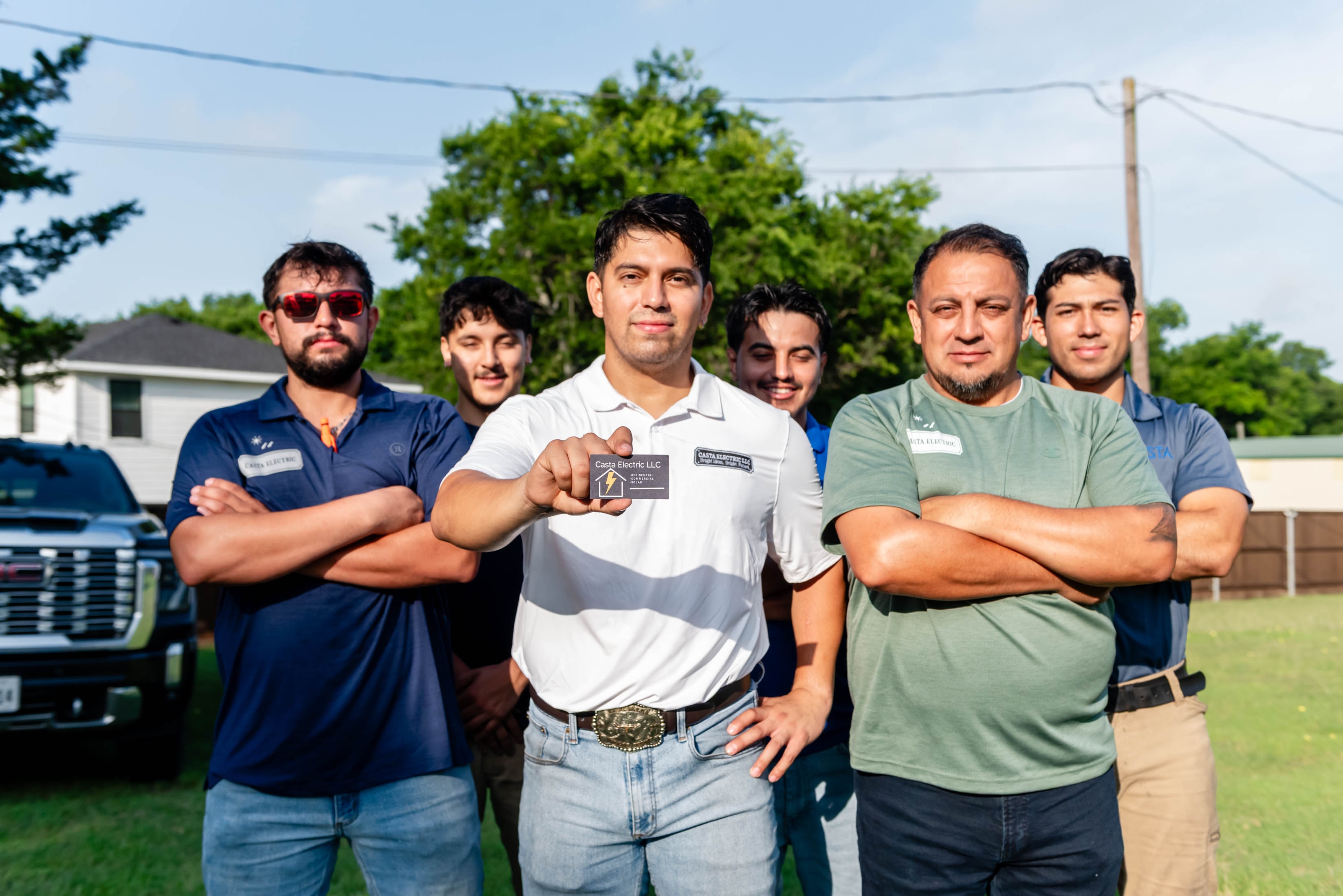 Casta Energy full team holding business card in front of service truck