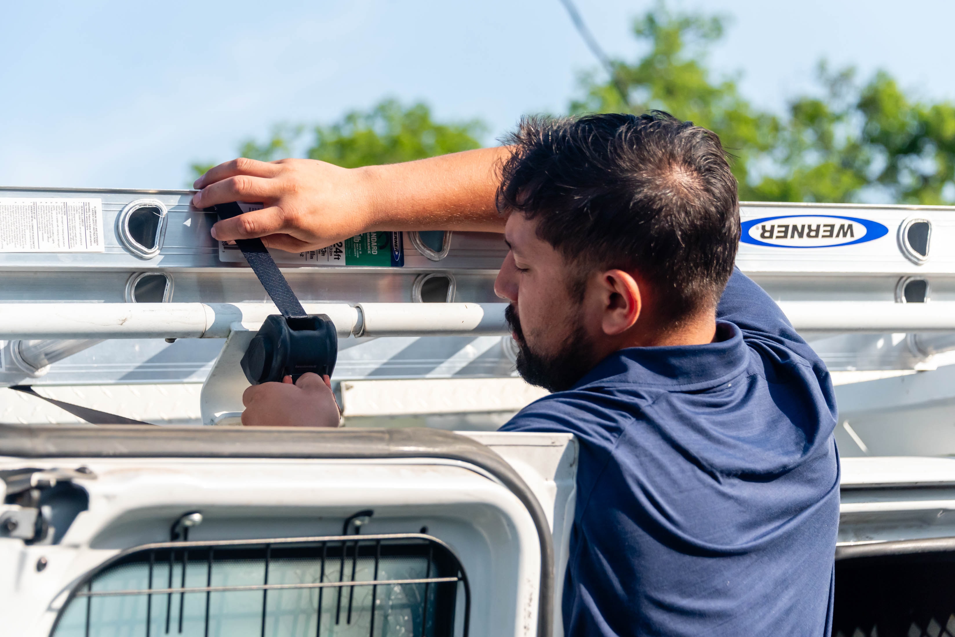 Casta Energy technician securing ladder on work van