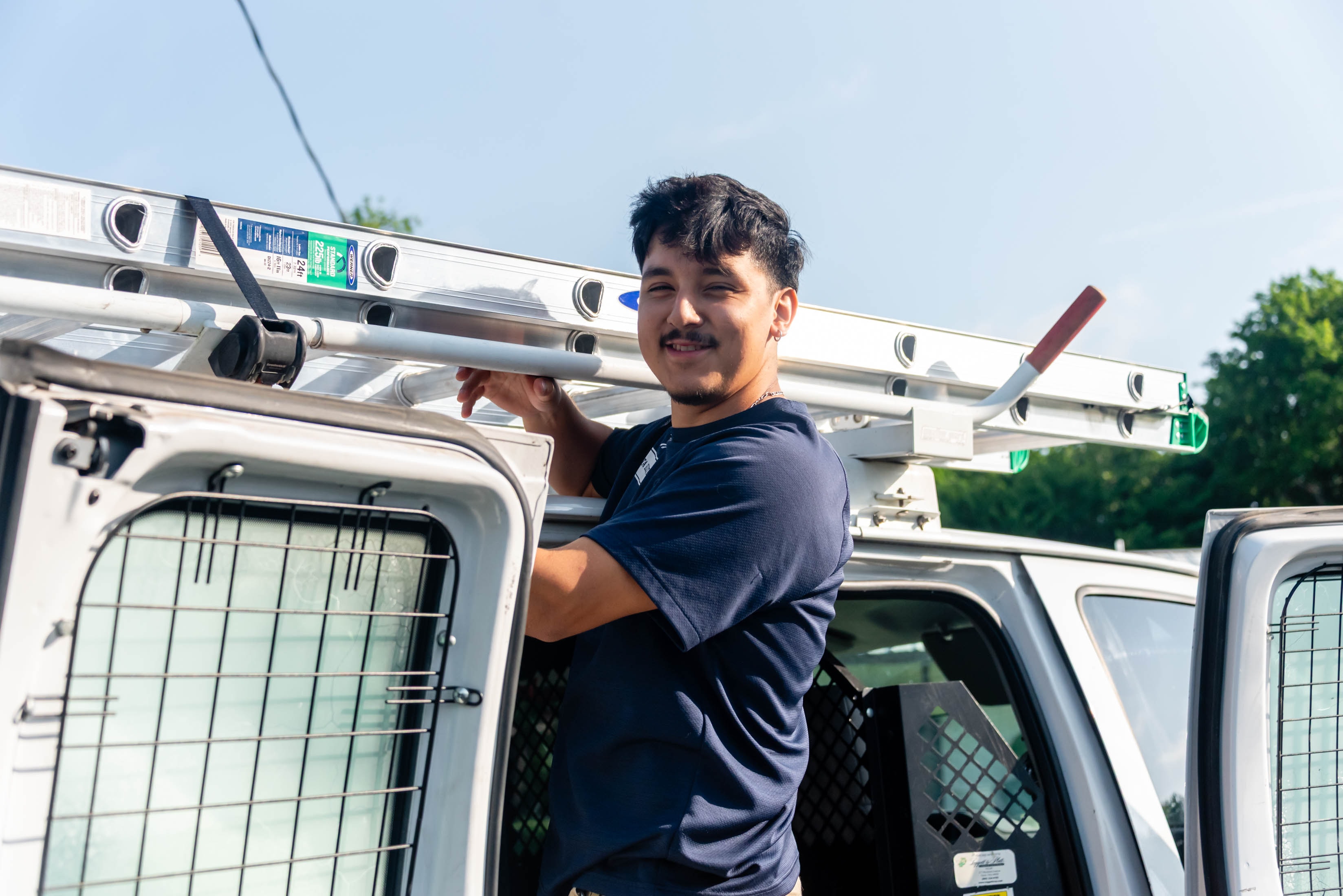 Casta Energy technician smiling by service van — friendly local electrician