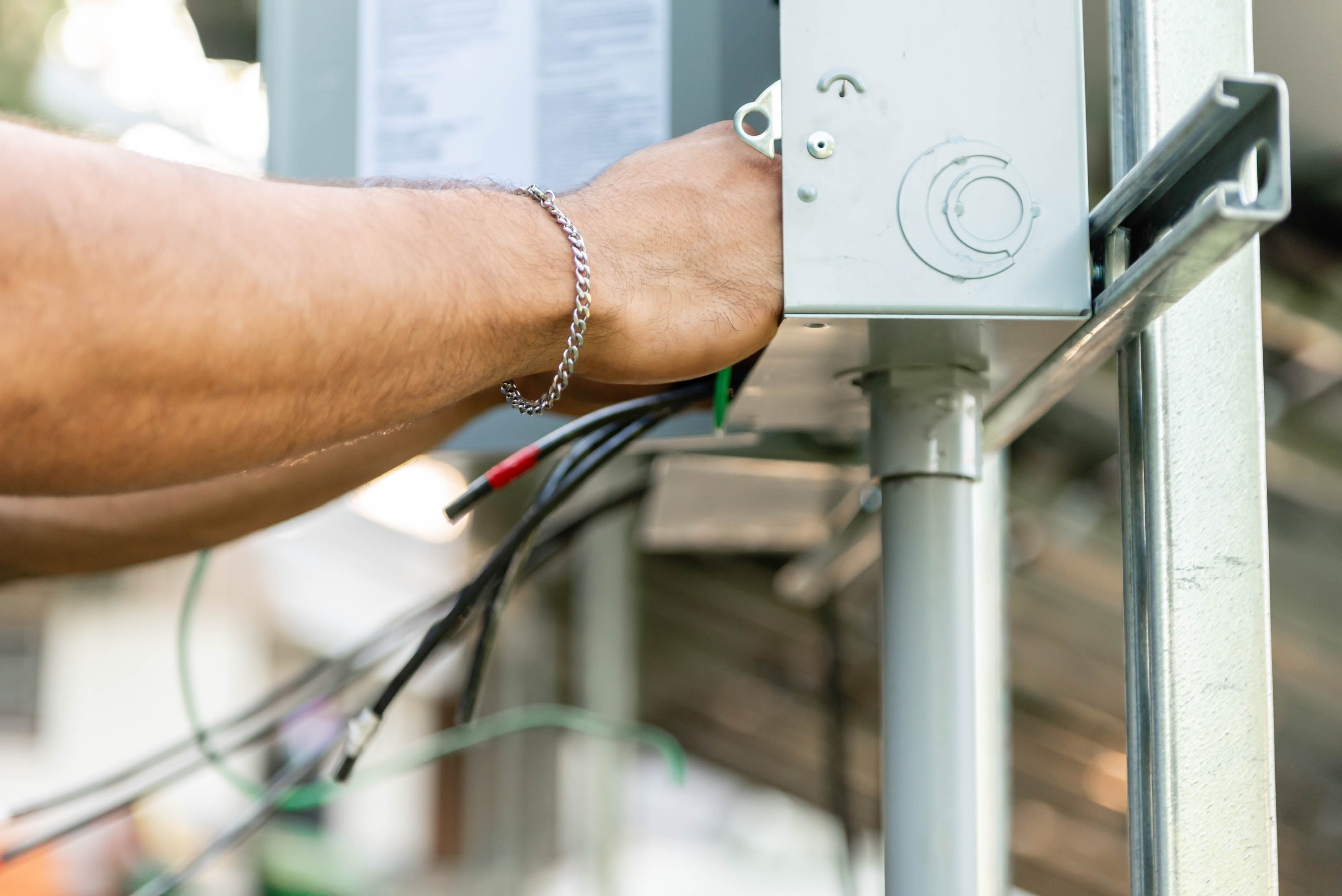 Casta Energy technician routing wiring into panel with conduit